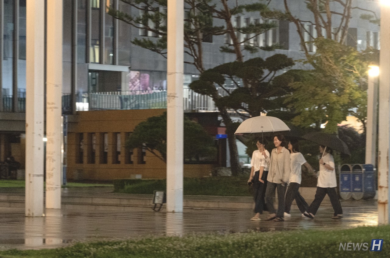 ▲ 학우들이 우산을 쓰고 야간 산책을 즐기는 모습.