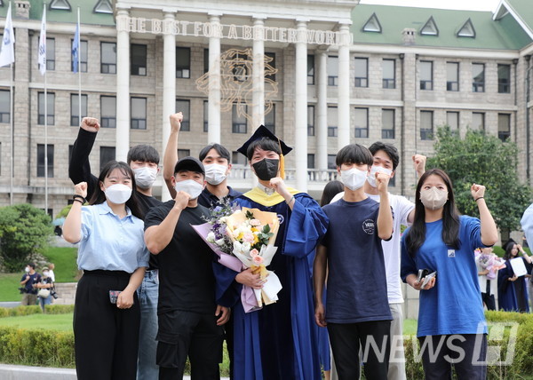 18일 서울 성동구 서울캠퍼스에서 학위수여식을 마친 졸업생이 지인들과 함께 기념사진을 촬영하고 있다. 