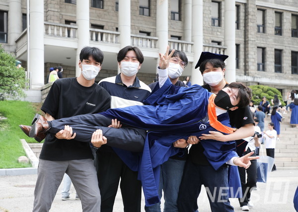 18일 서울 성동구 서울캠퍼스에서 학위수여식을 마친 졸업생이 지인들과 함께 기념사진을 촬영하고 있다.