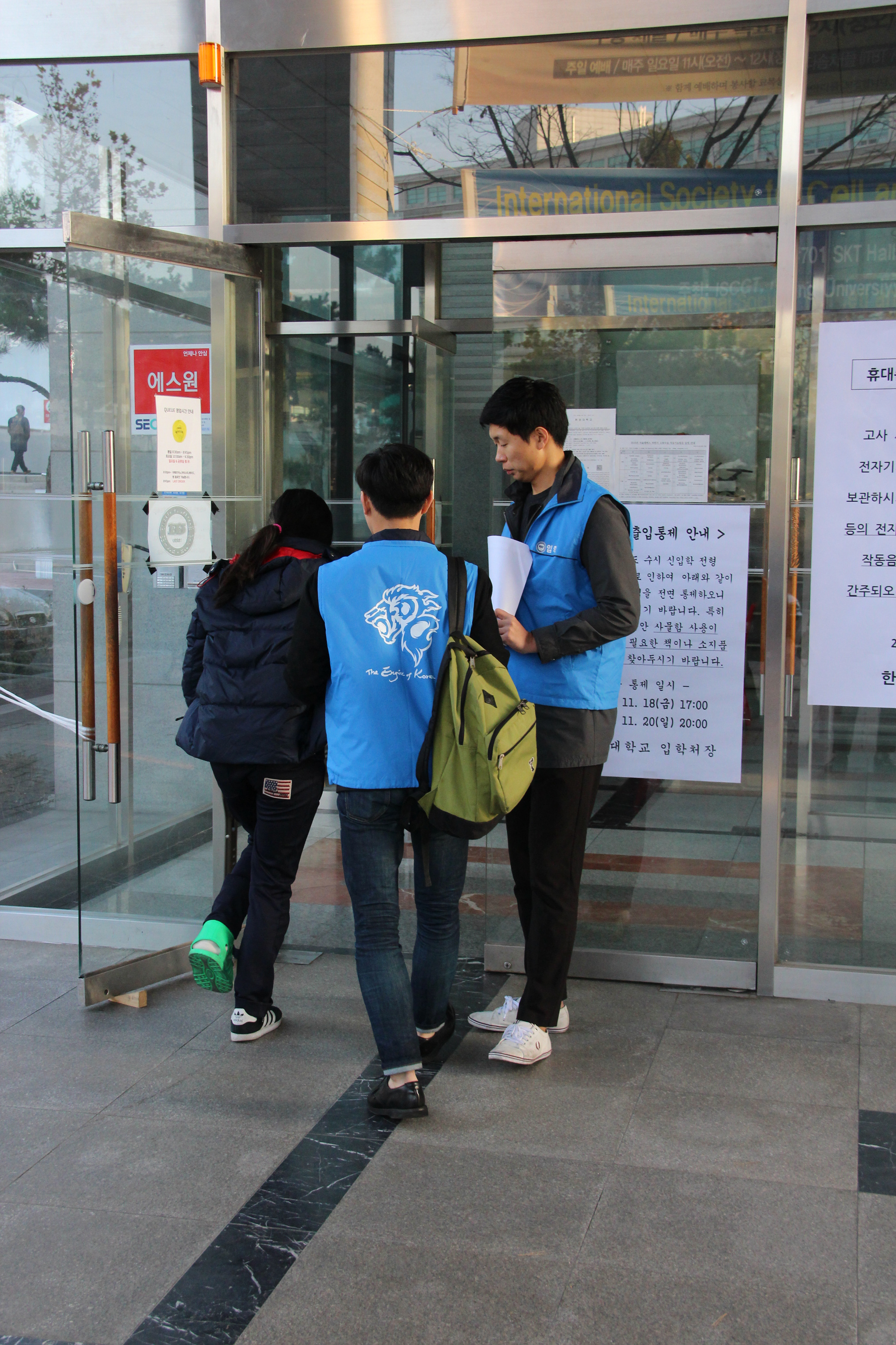 목발을 짚은 수험생이 안내요원의 도움을 받아 고사장으로 들어가는 모습