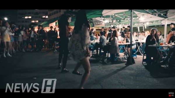 한마당 주점 앞에서 두 학생이 춤을 추고 있다 (ⓒ한양대 공식 유튜브)