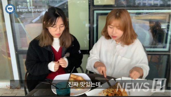 노천카페 조각피자 메뉴를 먹고 리뷰하고 있는 김민주 학생(왼쪽)과 김선희 학생 (ⓒ토토사이트 홍보 커뮤니티학교 총학생회 유튜브)