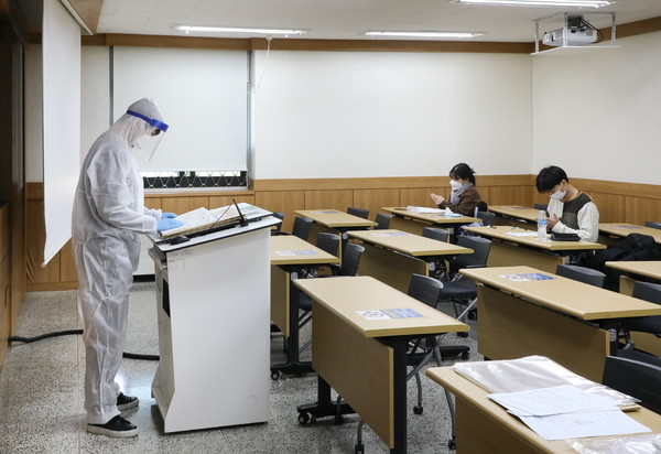 5일 오전 진행된 논술고사 비상고사장에서 감독관이 방역복을 입고 고사를 진행하고 있다.