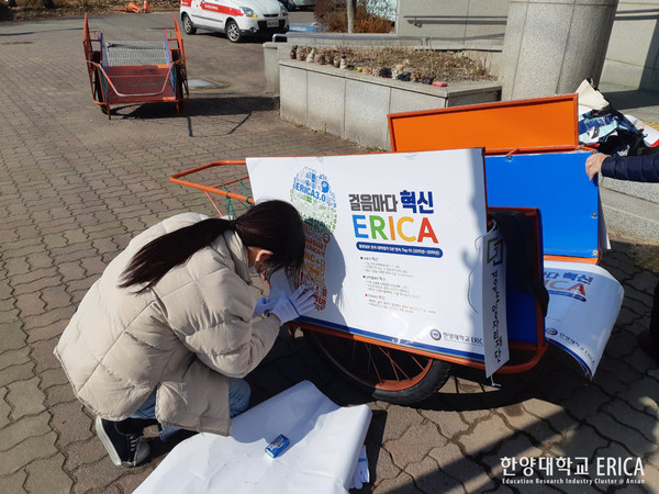 '희망한대'가 리어카에 광고를 부착하고 있다.