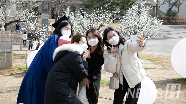 17일 서울 성동구 서울캠퍼스에서 졸업생이 온라인으로 열리는 졸업식의 아쉬움을 달래고자 친구들과 함께 기념사진을 촬영하고 있다.