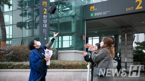 17일 서울 성동구 서울캠퍼스에서 졸업생이 온라인으로 열리는 졸업식의 아쉬움을 달래고자 학위모를 던지며 기념사진을 촬영하고 있다.