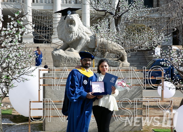 17日，在首尔城东区首尔校区里，外国毕业生正在和家人一起拍摄纪念照片。