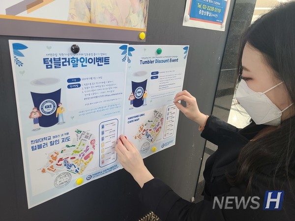 ▲ CFP 팀원이 교내 게시판에 직접 제작한 텀블러 할인 이벤트 포스터를 붙이고 있다.