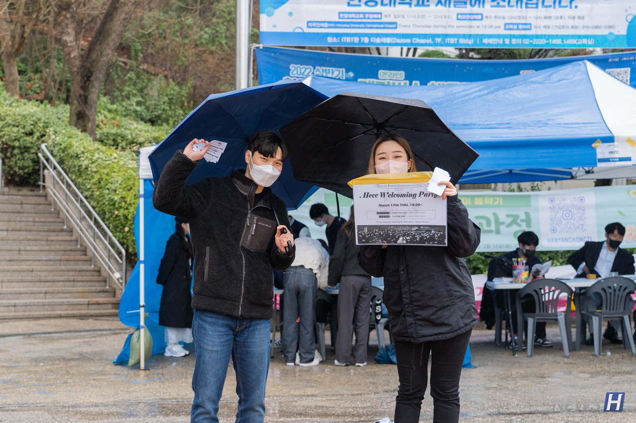 ▲ 비가 오는 날씨에도 우산을 들고 동아리 명함을 나눠주고 있다.