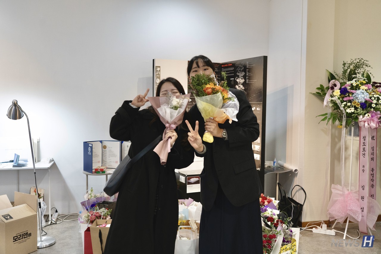 ▲ 졸업생(왼쪽)이 전시를 축하하기 위해 찾아온 지인(오른쪽)과 포즈를 취하고 있다.
