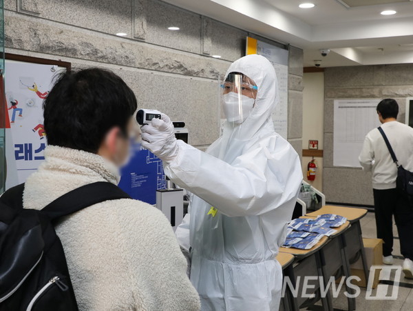 27일 오전 서울 성동구 서울캠퍼스에서 방역 관계자가 수험생 대상 체온측정을 진행하고 있다. 