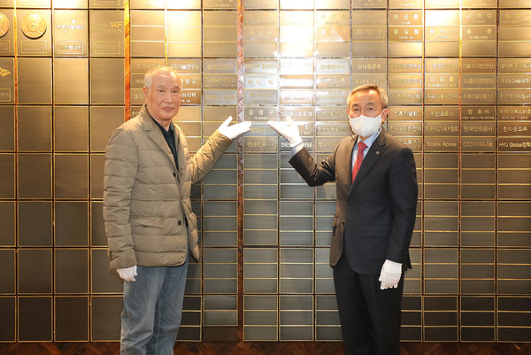 강명구 변리사와 김우승 총장이 신본관 1층에 위치한 명예의 전당에 부착된 강명구 변리사의 현판 앞에서 기념사진 촬영을 하고 있다.