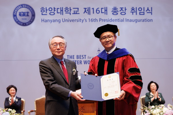 Dr. Kim Chong-yang, Hanyang Foundation Chairman of the Board of Trustees(left), delivers a certificate of appointment to Dr. Lee Ki-jeong, the 16th president of Hanyang University, and takes a commemorative photo in the inauguration ceremony held at Hanyang University's Paiknam Concert Hall in Seongdong-gu, Seoul on the morning of March 2.