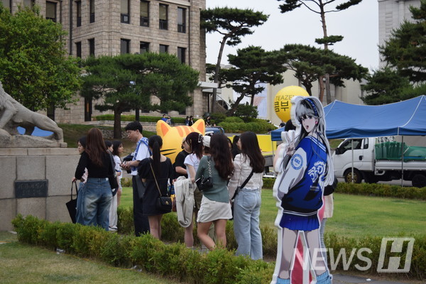 ▲ 서울캠퍼스 사자상 앞에 설치된 웹툰 '이두나!'의 등신대와 사진을 찍기 위해 한양인이 줄 서 있다. ⓒ 황지빈 기자