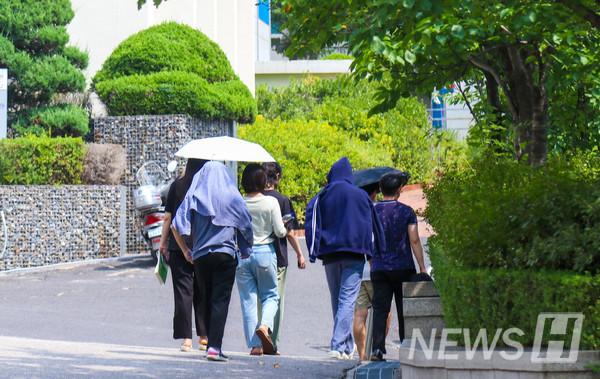 ▲ 토토사이트 해킹 신고인들이 양산을 쓰거나 겉옷을 걸치는 등 각자의 방식으로 햇빛을 피해 이동하고 있다.