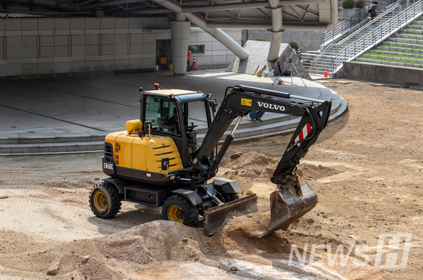 ▲ 노천극장은 보도블록 공사 전 포클레인으로 모래를 정리하고 있다.