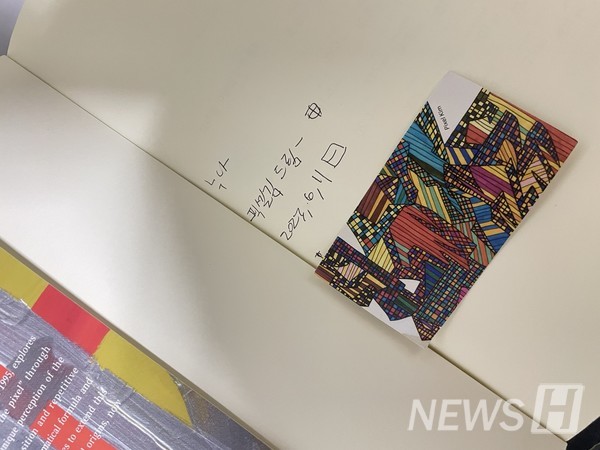 ▲ 김 씨는 김현우 작가가 출간한 드로잉 아카이브 책에 사인을 받았다. 그는 김현우 작가 작품의 대표적인 특성으로 즉흥성과 다양한 색상, 순수한 표현 등을 언급했다. ⓒ 김아리 학생
