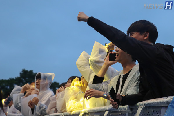 ▲ 우산 소지가 불가능한 공연장에서 우비를 입은 관람객들이 축제를 즐기고 있다.
