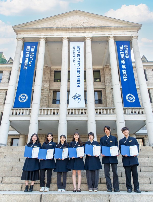 역사관 앞에서 임명장을 들고 포즈를 취하고 있는 하이디