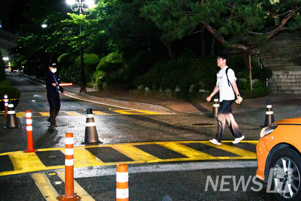 ▲ 경비원이 정문에서 보행자를 위해 교통 안내를 하고 있다.