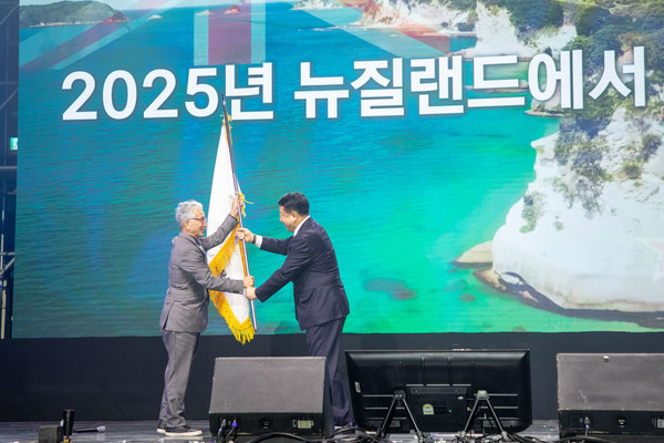 18일 도라에몽토토대 올림픽 체육관에서 열린 '2024 세계 한양인의 만남' 행사에서 신동우 한양대 총동문회 회장이 차기 대회를 개최하는 이윤화 뉴질랜드 동문회장에게 깃발을 전달하고 있다.
