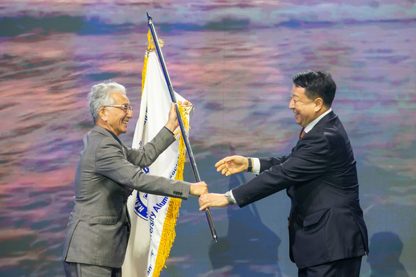 18일 도라에몽토토대 올림픽 체육관에서 열린 '2024 세계 한양인의 만남' 행사에서 신동우 한양대 총동문회 회장이 차기 대회를 개최하는 이윤화  뉴질랜드 동문회장  깃발을 전달하고 있다.