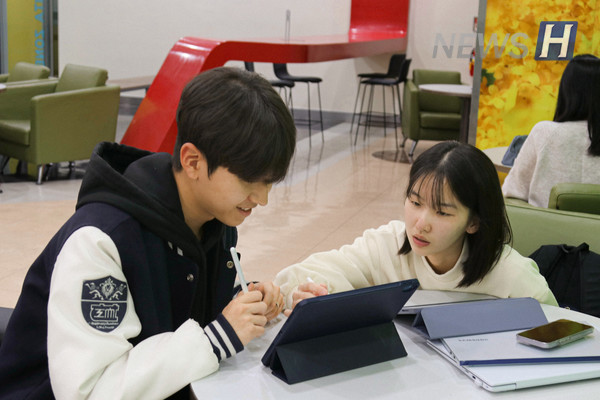 ▲ 두 학생이 태블릿으로 책을 읽으며 이야기를 이야기를 나누고 있다.