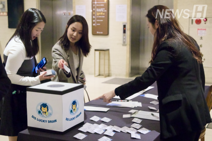 ▲ 행사에 참석한 동문이 접수대에서 명찰을 확인하고 있다.