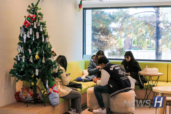 ▲ 연말을 맞아 트리가 설치된 국제관 라운지에서 휴식을 취하는 학생들.