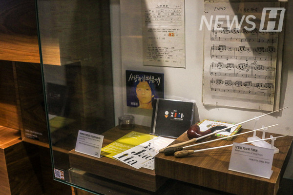 ▲ Alumnus Yoo Jae-ha's CD and Hanyang University College of Music Professor Jang Il-nam's music score and baton are in display. 