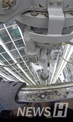 ▲ Nam cleaning the windows of Lotte World Tower as part of an immersive report. ⓒ Nam Hyeong-do