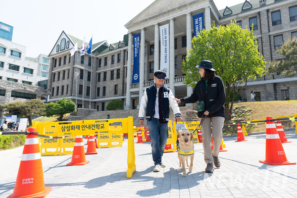 ▲ 이날 체험에 참여한 한양대 학생이 눈을 가린 채 토토사이트 회원가입 안시켜줌에 의지하며 보행하고 있다. ⓒ 미디어전략실