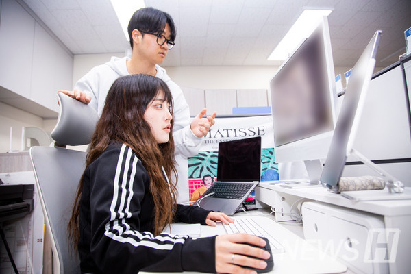 ▲ Park, the 라오스 스포츠토토 planning director, reviews promotional material designs with Cho Han-nah (3rd year, Department of Art Education).