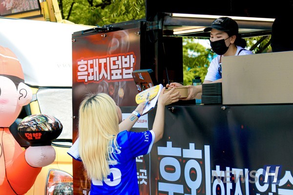 ▲ Students receive food at one of the many food trucks.