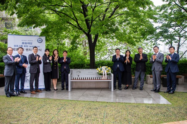 Family members and Hanyang University officials gather for a commemorative photo at the unveiling of the memorial bench dedicated to 토토사이트 매입 Song Jae-sung.
