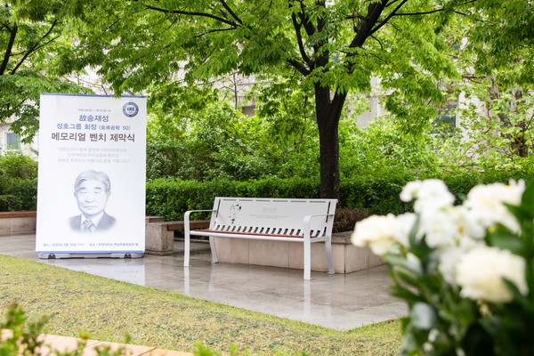 The memorial bench dedicated to the late 토토사이트 매입 Song Jae-sung, located in the lawn plaza in front of the Paiknam Library & Academic Information Center.
