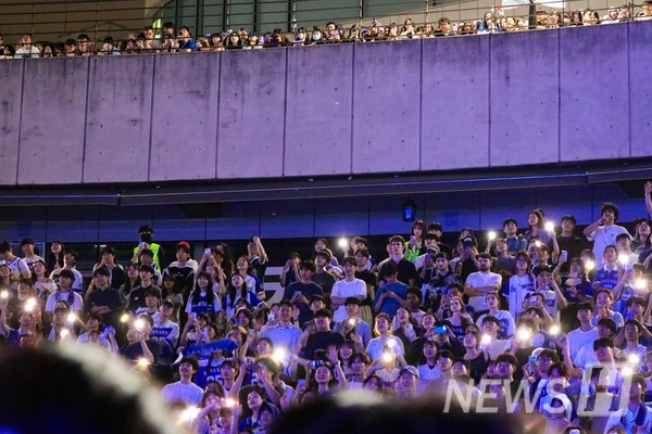 ▲ 무대를 향해 휴대폰 불빛을 흔드는 학생들.