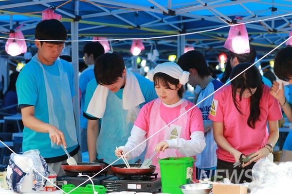 ▲ Students busily prepare food, with the smell of sizzling snacks drifting into the open air.