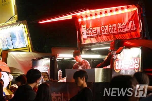 ▲ A crowd bustles around food trucks, eager to grab a bite.