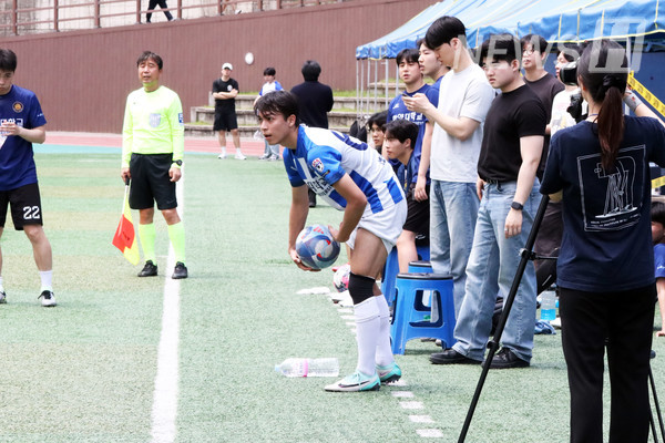 ▲ A player from Team Lion A prepares to throw the ball in from the touchline.