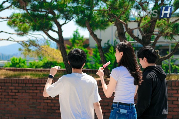 ▲ A student strolls across campus cooling off with ice cream in hand.