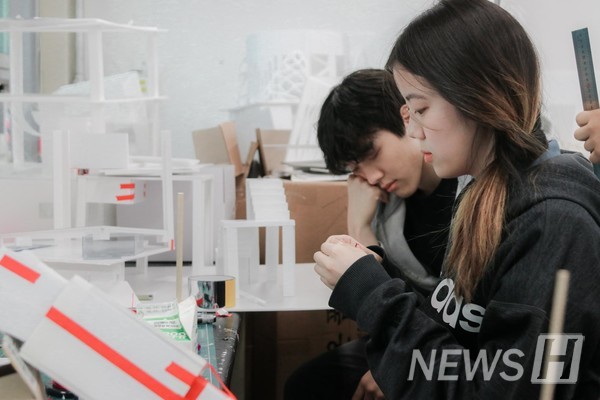▲ Students working overnight in the studio in preparation for their final design presentations. In the back, a student catches a short nap.
