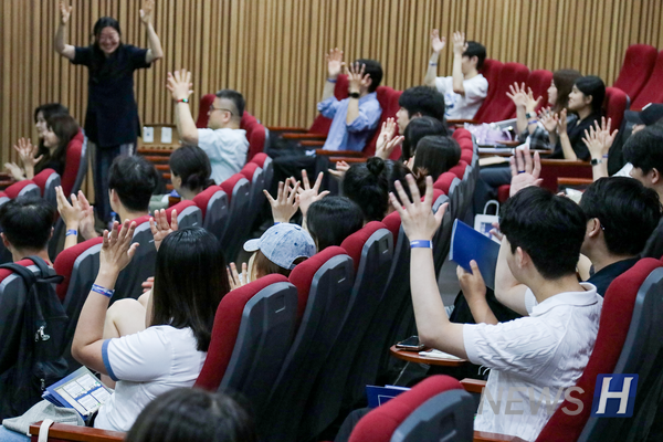▲ The audience learns and practices the sign for “Welcome” together.