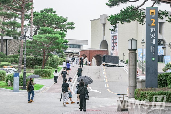 ▲ Students making their way to campus early in the morning, undeterred by the light rain.