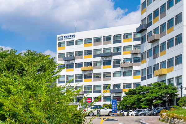 The College of Natural Sciences building stands out with its summer look, accentuated by a touch of yellow.