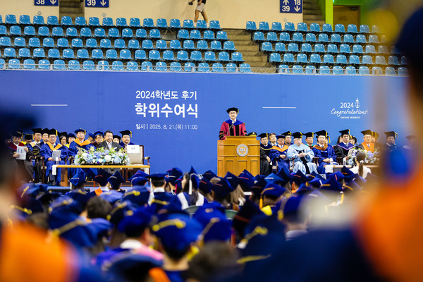 무대 위에서 교수진과 함께 학위수여식이 진행되고 있다.