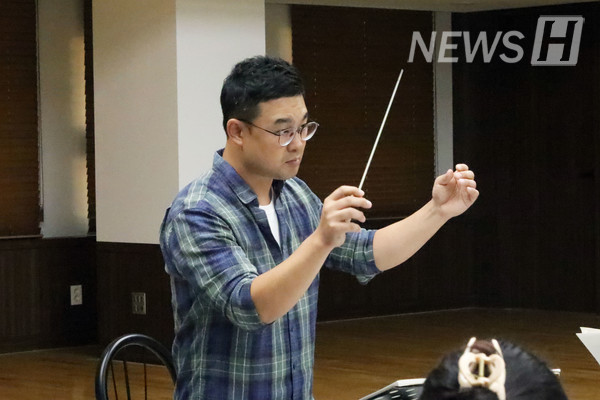 ▲ 한명 한명 세심히 살펴보며 합주를 이끄는 지휘자. ▲ The conductor leads the ensemble, watching over each member carefully.