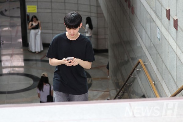 ▲ Around 10:40 a.m., a student checks his smartphone while coming out through Aejeemun(Hanyang Station Exit #2). 