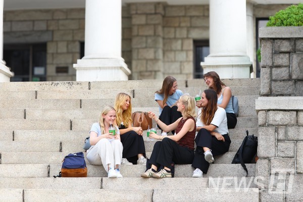 ▲ Sitting on the steps in front of the History Museum, students are having joyful conversations. 