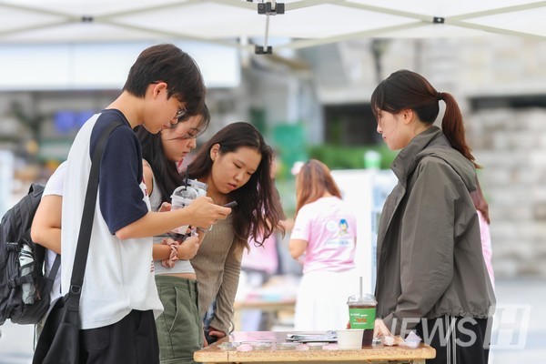 ▲ Hanyang's volunteer supporters ‘Hanul’ greet returning students with a semester-opening event giving out its goods. 
